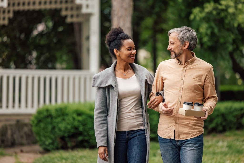 an older couple walking and talking outside together